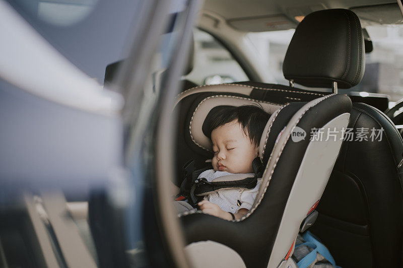 asian chinese baby boy sleeping in baby seat back seat of car during outing with his parent